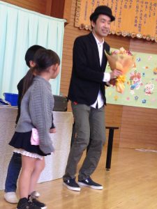 幼稚園児から花束をもらうマジシャンひろしつちや