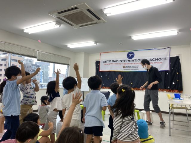 元気に手をあげる子供たち 東京ベイインターナショナルサマースクールでマジシャンの子供向けマジックショーを英語で